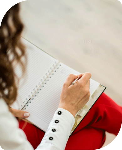 Picture of a girl writing on a diary.