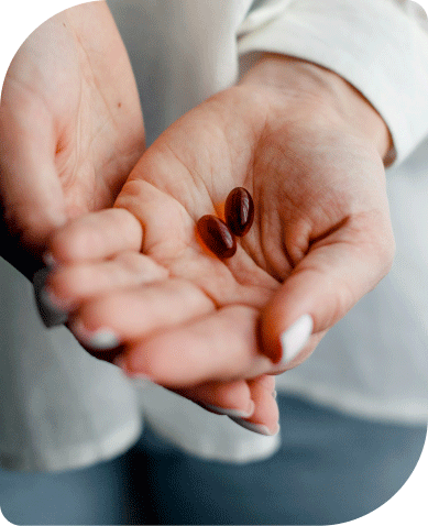 Health Store Red capsules on a palm.